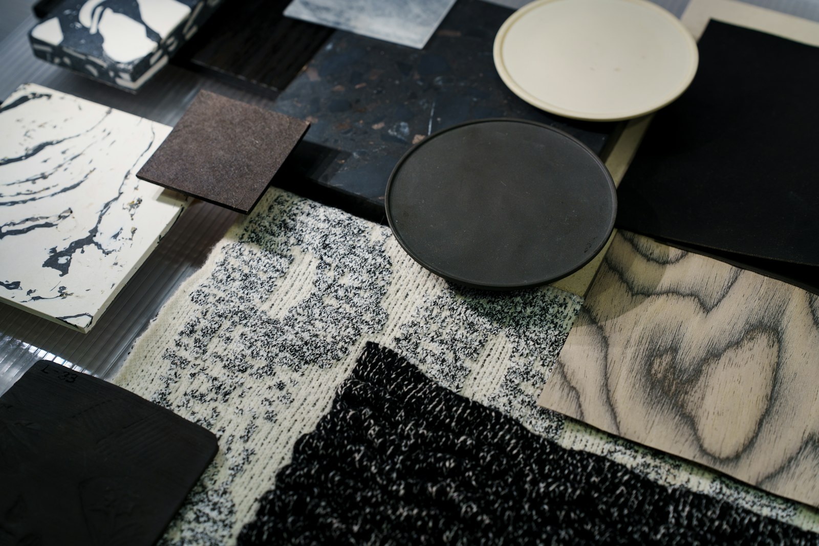 Interior material samples: stone, terrazzo, wood veneer and textiles laid out on a table
