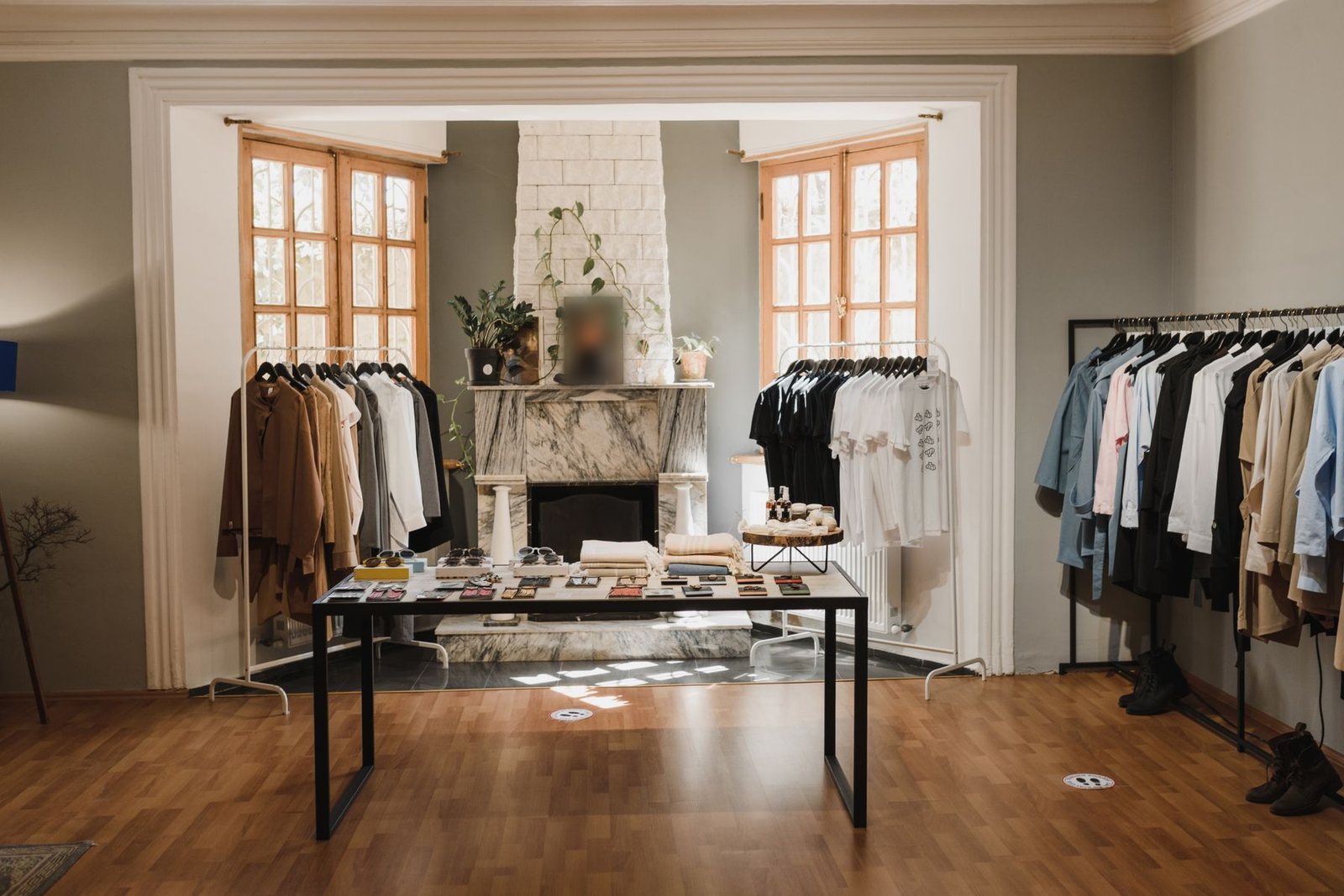 Temporary boutique in a period room with freestanding clothing rails and a steel display table